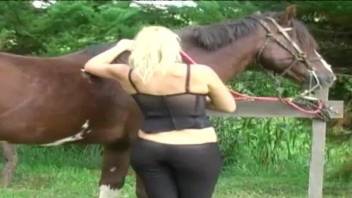 Fine blonde shoves massive horse dick in both her love holes