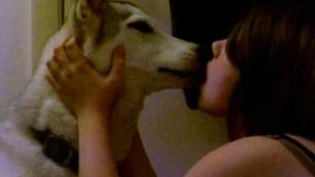 A white dog licks a seductive brunette animal lover whore
